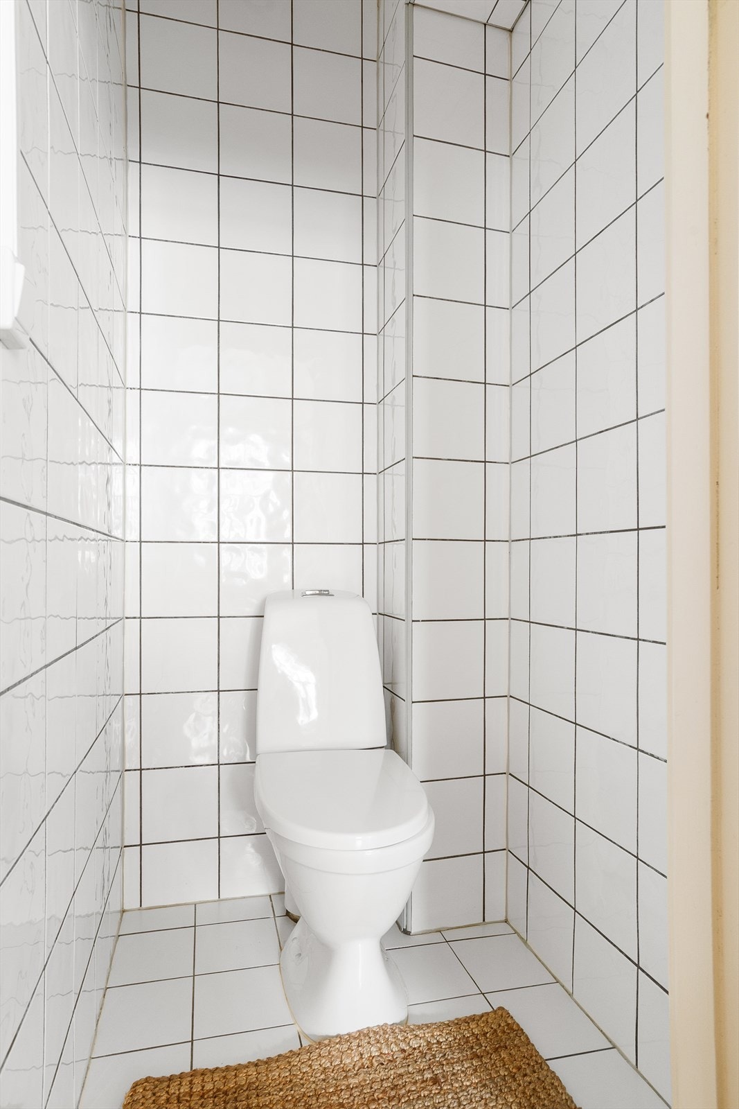 Separat toalettrom med fliser på gulv og vegger med malte overflater på himling. Innredet med frittstående toalett. Galleribilde