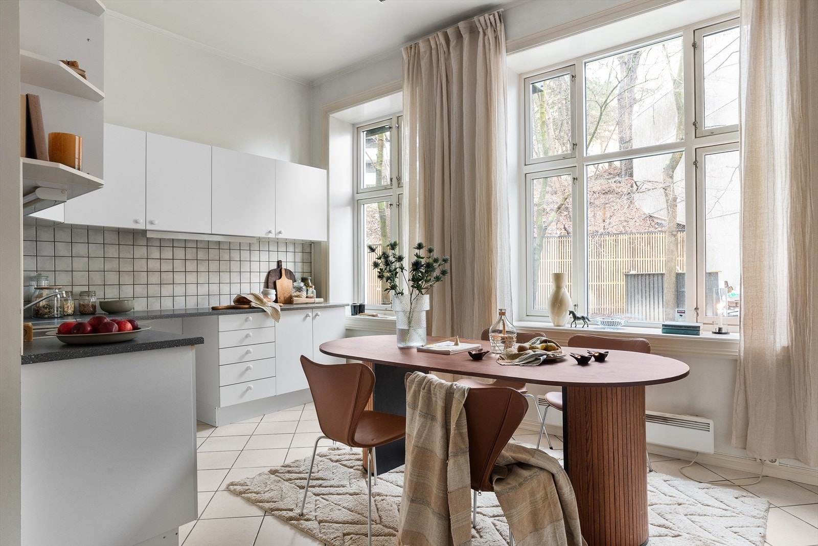 Kjøkkenet har enkel innredning med slette fronter, fliser og belysning over laminat benkeplate med oppvaskkum og blandebatteri. Galleribilde