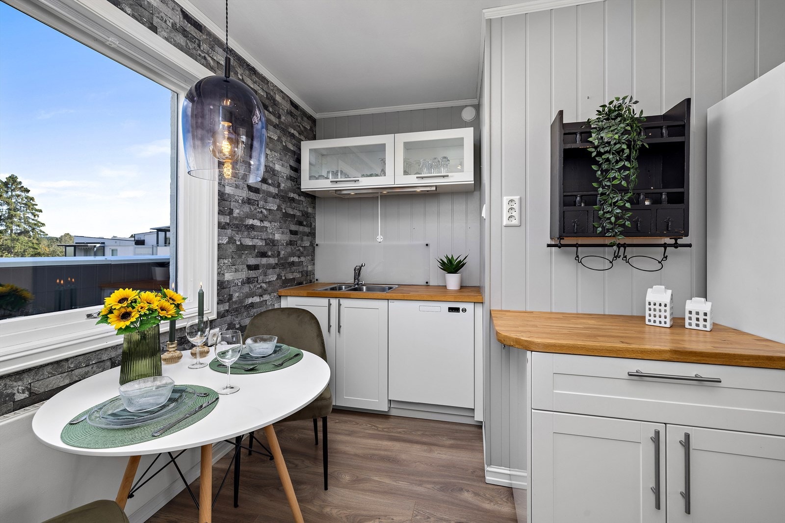 Lys og innholdsrik kjøkkeninnredning med integrerte hvitevarer Galleribilde