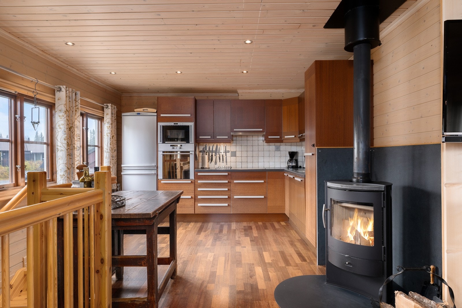 Kjøkkenet har en tidløs innredning med laminerte skrog, glatte fronter og laminert benkeplate med kjøkkenkum. Galleribilde