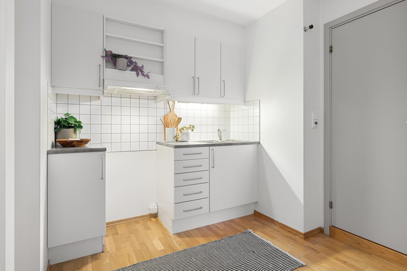 Innredning med mekanisk avtrekksvifte over stekesonen og opplegg for komfyr og kjøleskap Galleribilde