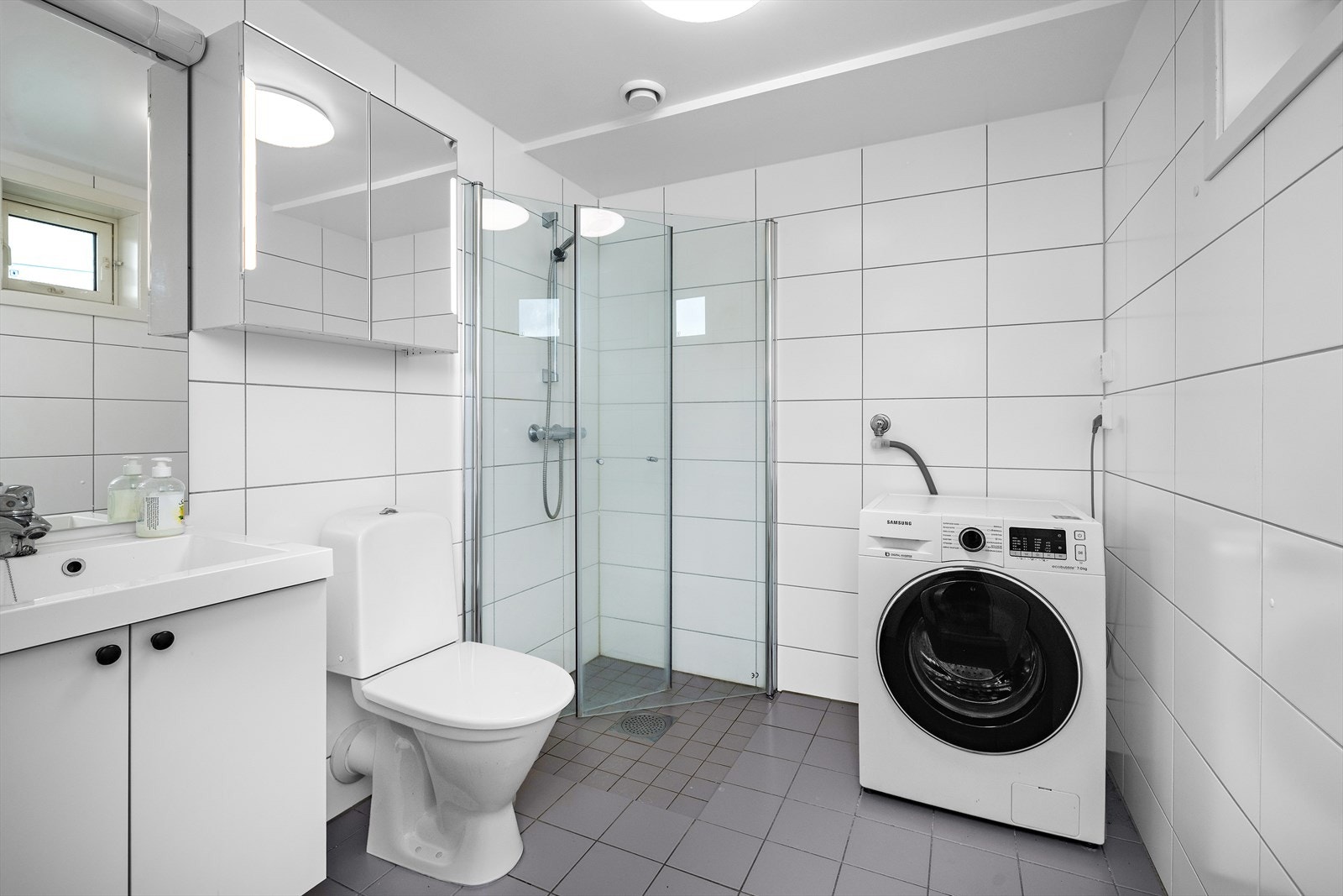 Tidløst og helfliset bad fra byggeåret 2016. Det er et praktisk opplegg for vaskemaskin på badet. Galleribilde