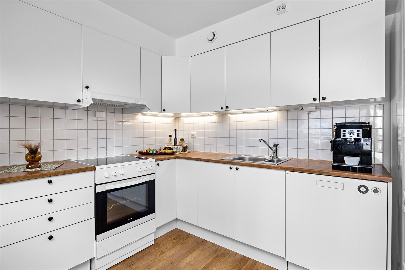 Det er flislagt vegg over benkeplaten for enkelt renhold, samt belysning under overskapene som gir godt arbeidslys. Galleribilde