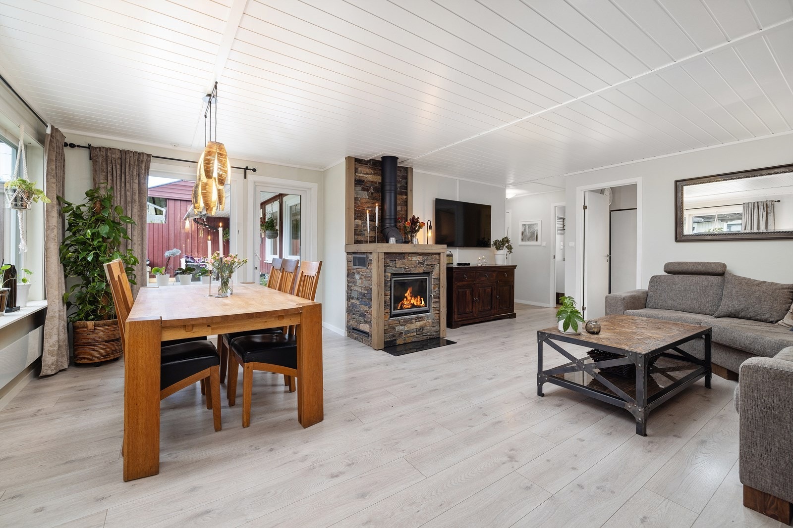 Lys og moderne stue med lekkert ildsted som rommets naturlig blikkfang. Galleribilde