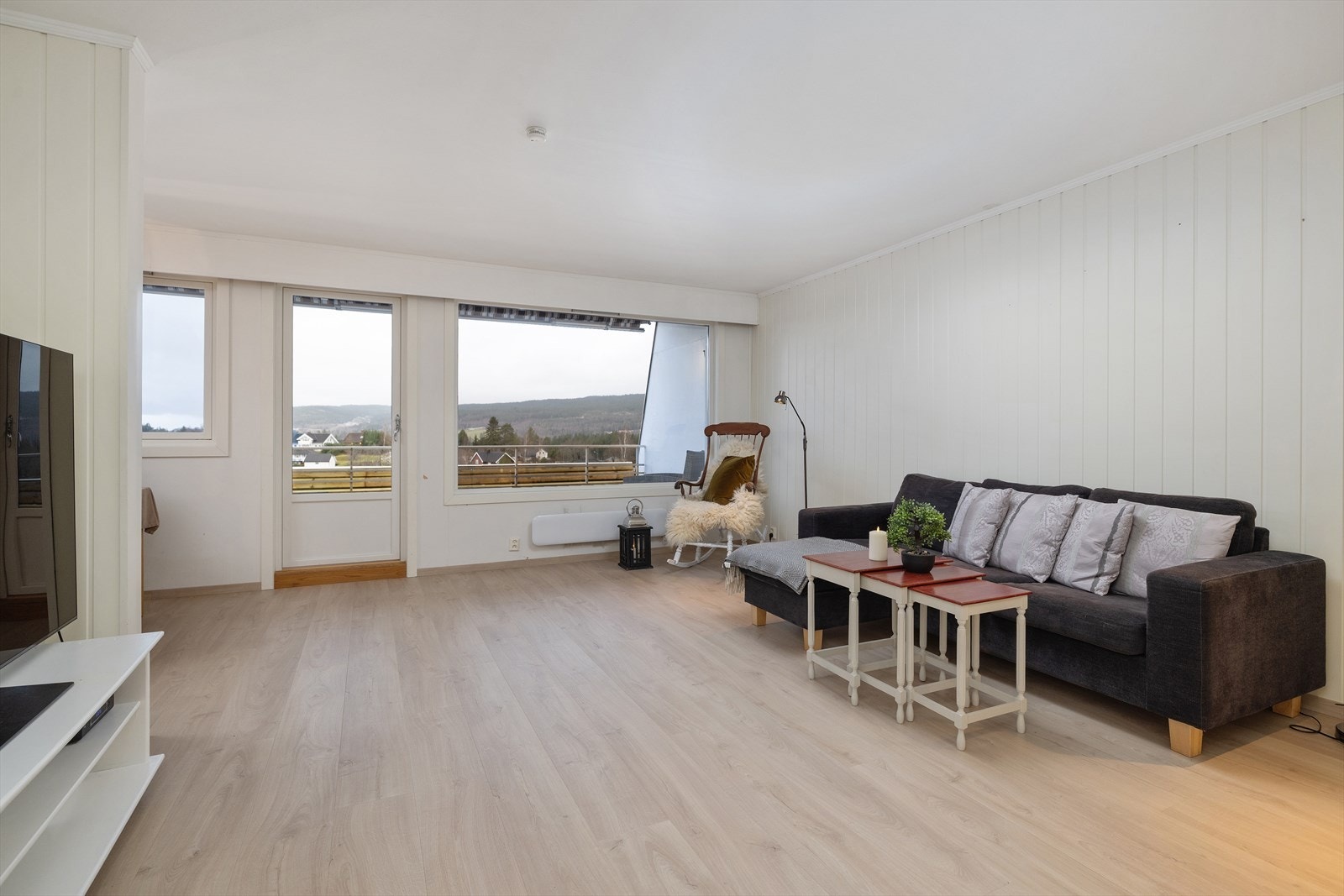 Åpen og solrik stue med flere møbleringsmuligheter Galleribilde