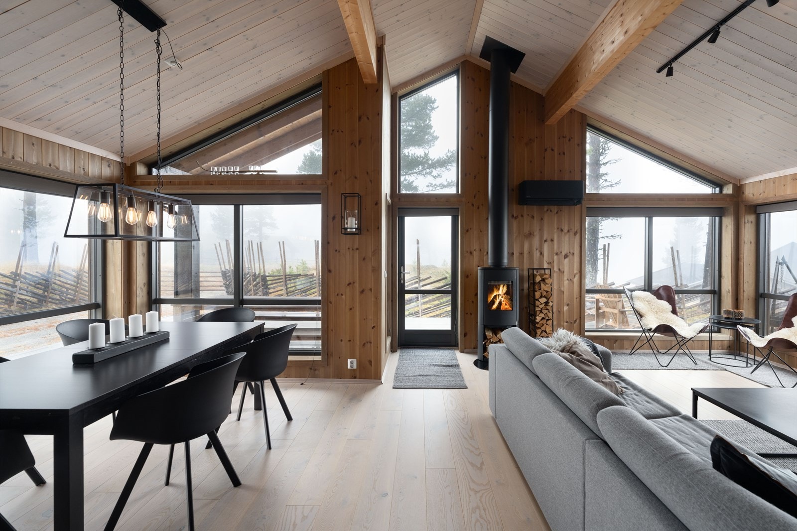 Moderne hytte med store vinduer, som gir rikelig med naturlig lys og en fantastisk utsikt til naturen utenfor. Galleribilde