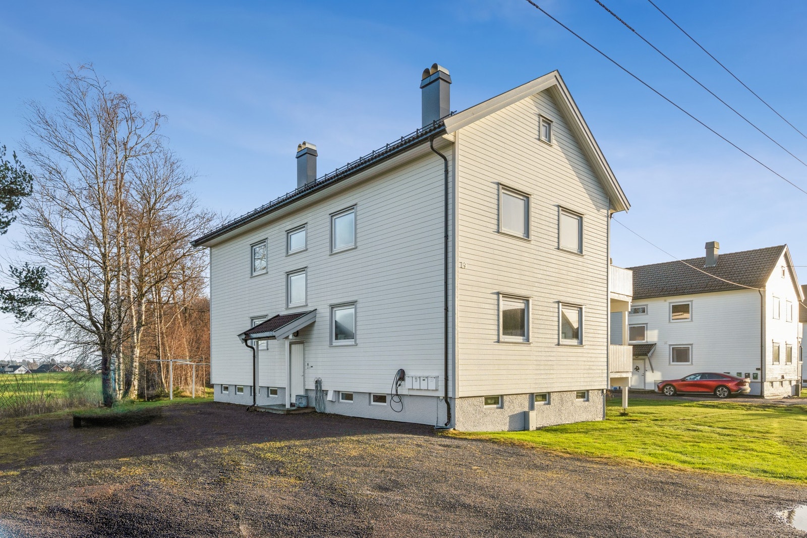 Gruset gårdsplass med biloppstillingsplass. Galleribilde