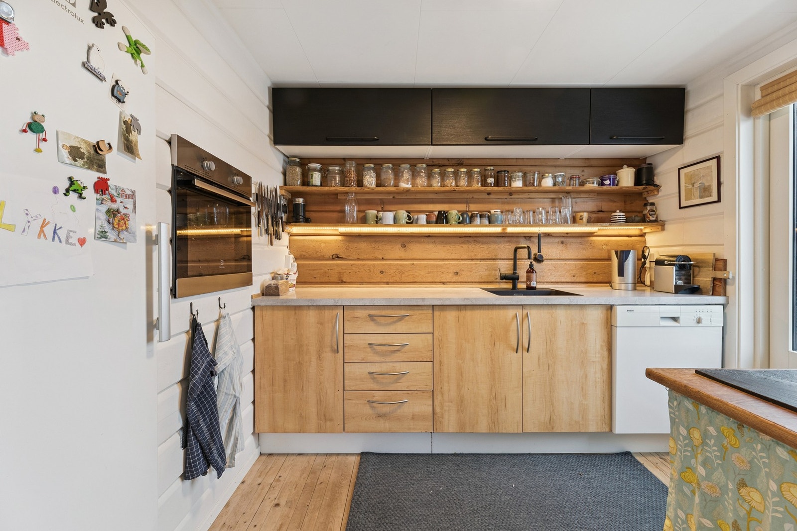 Kjøkkenet har innredning med glatte fronter og benkeplate av laminat og heltre Galleribilde