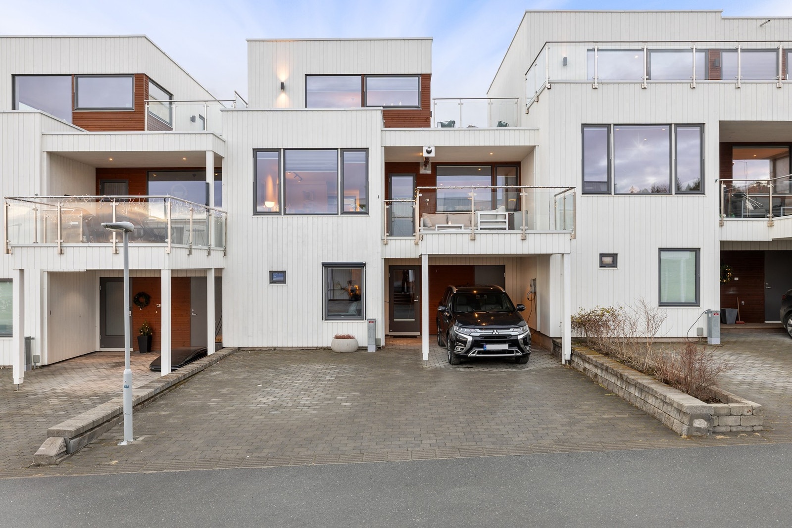 Parkeringsplass under carport og på eiendommens innkjørsel. Montert El-bil lader. Galleribilde