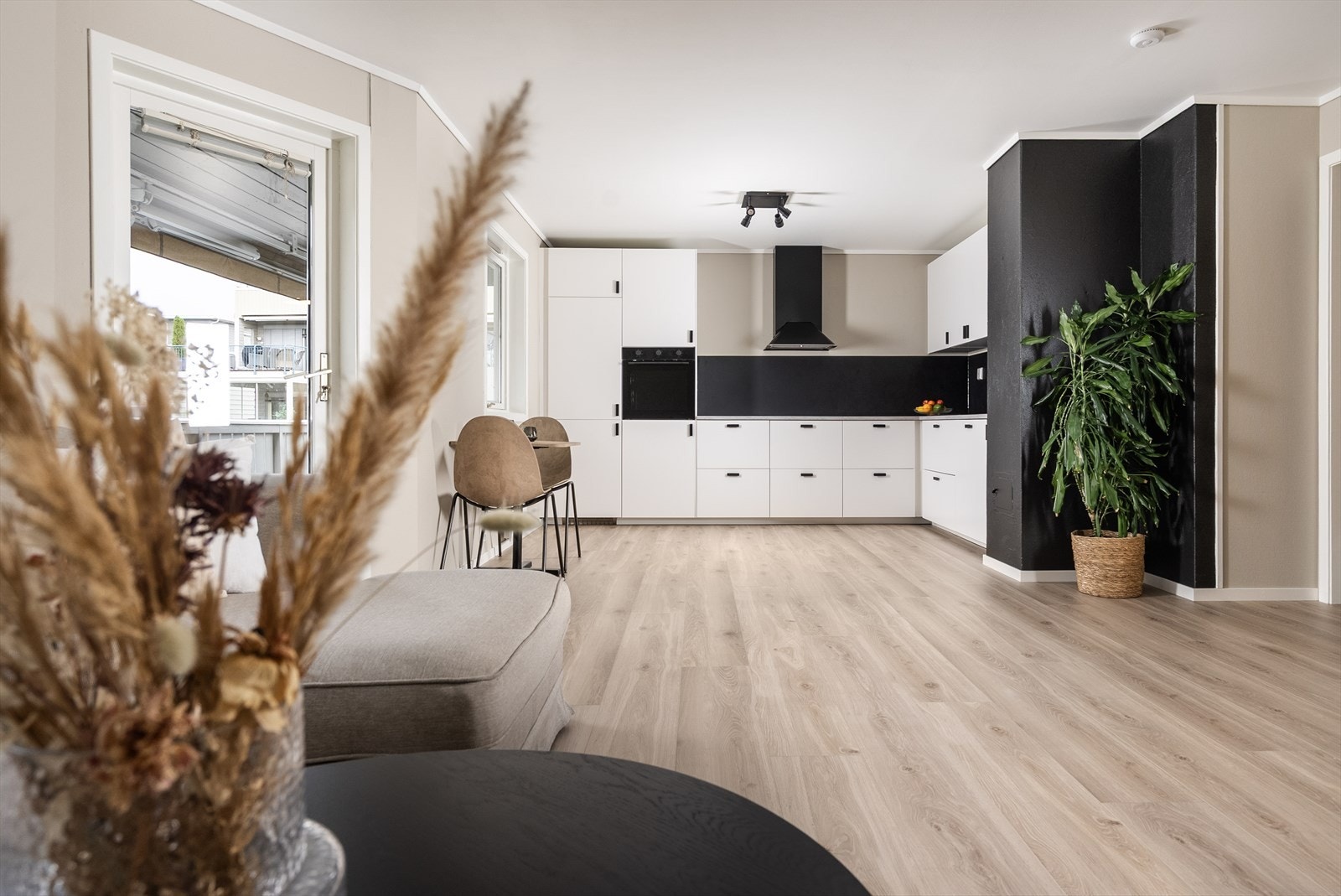 Stuen har en åpen løsning mot det nye kjøkkenet som gjør at rommet føles som et åpent og sosialt allrom. Galleribilde