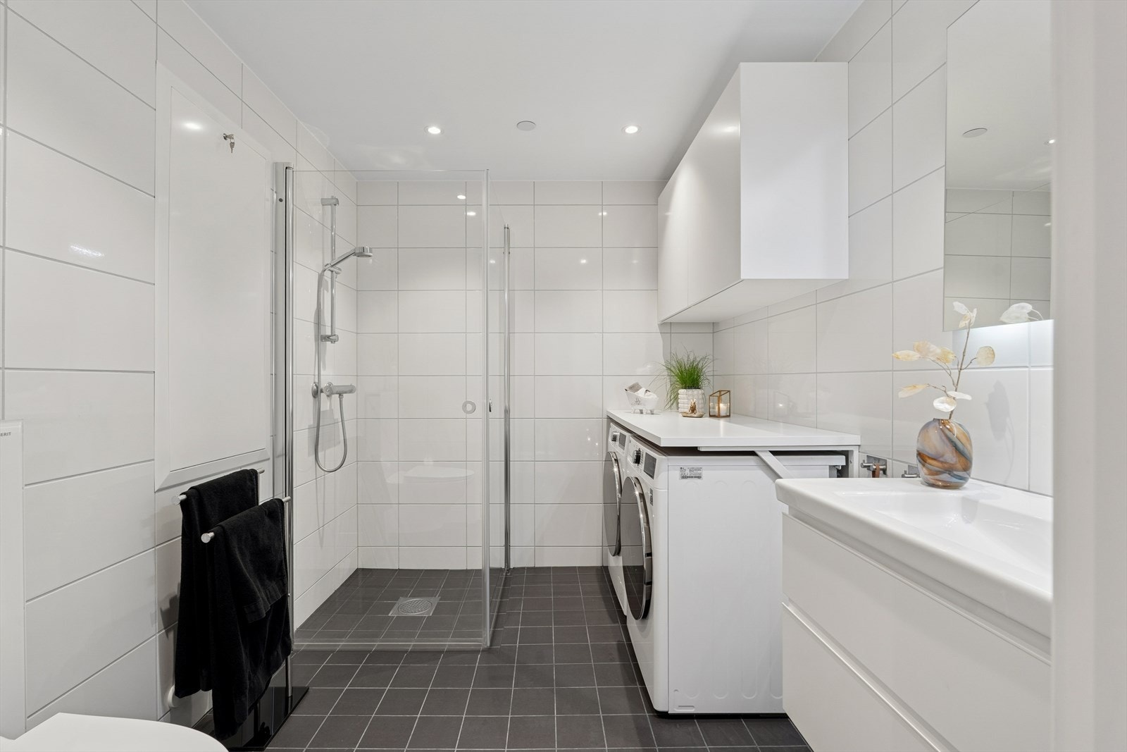 Romslig baderom med pen og praktisk innredning godt tilpasset vaskemaskin og tørketrommel. Galleribilde
