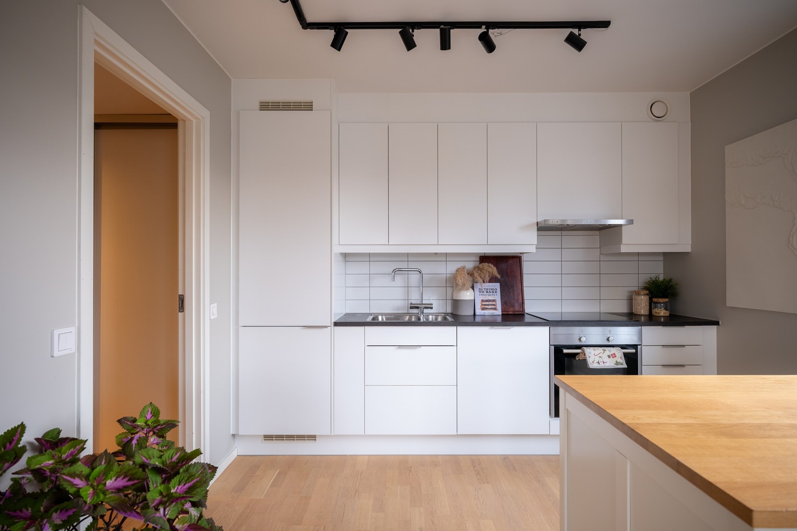 Det er lys kjøkkeninnredning med slette fronter, laminat benkeplate og oppvaskkum av stål. Galleribilde