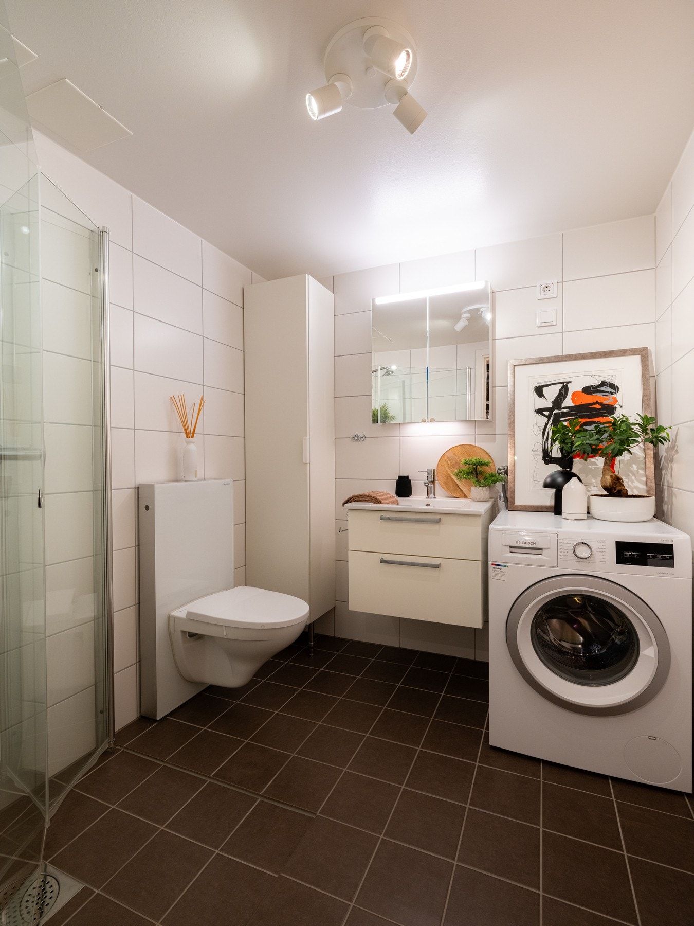 På badet er det innredning med slette fronter og servant over, speil, vegghengt toalett og dusjvegger/hjørne. Galleribilde