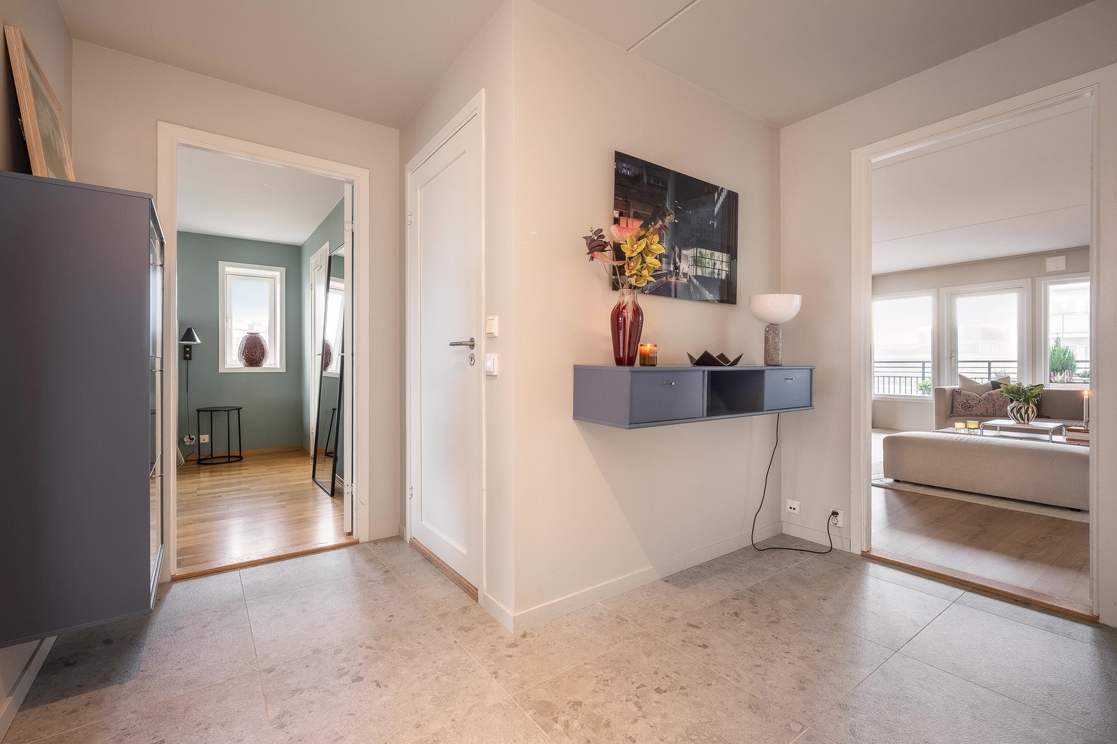 Innbydende entré som fungerer som et naturlig knutepunkt mellom rommene i leiligheten. Galleribilde