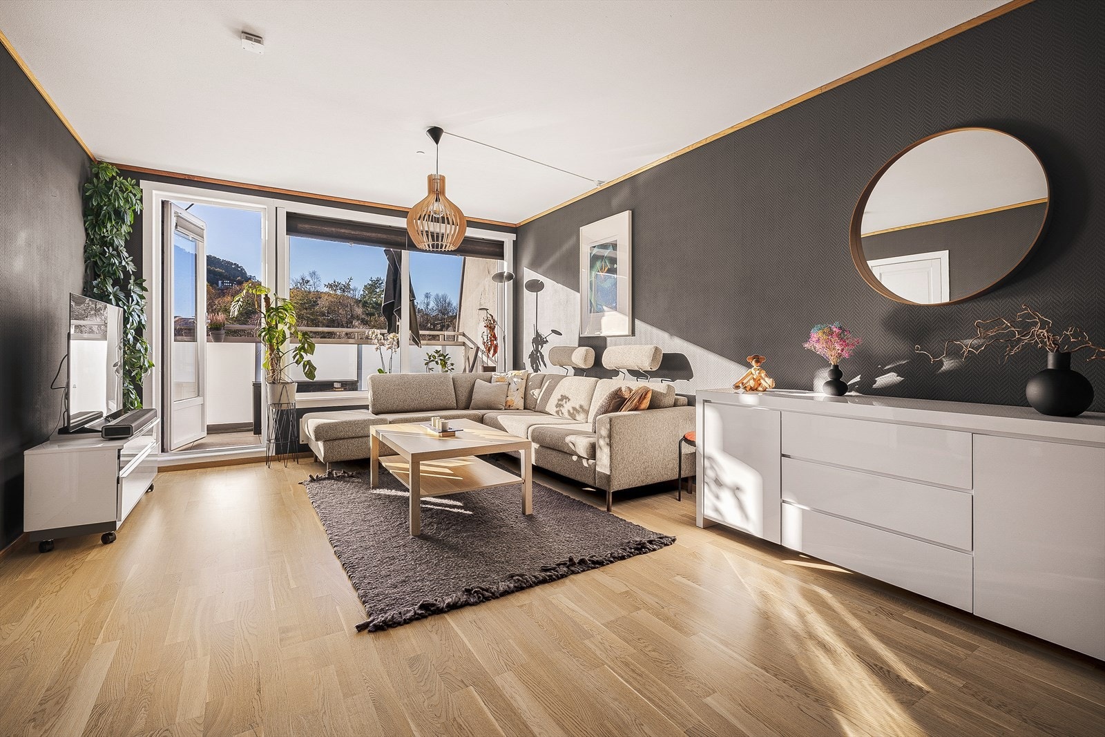 Romslig stue med store vindusflater og utgang til balkong Galleribilde