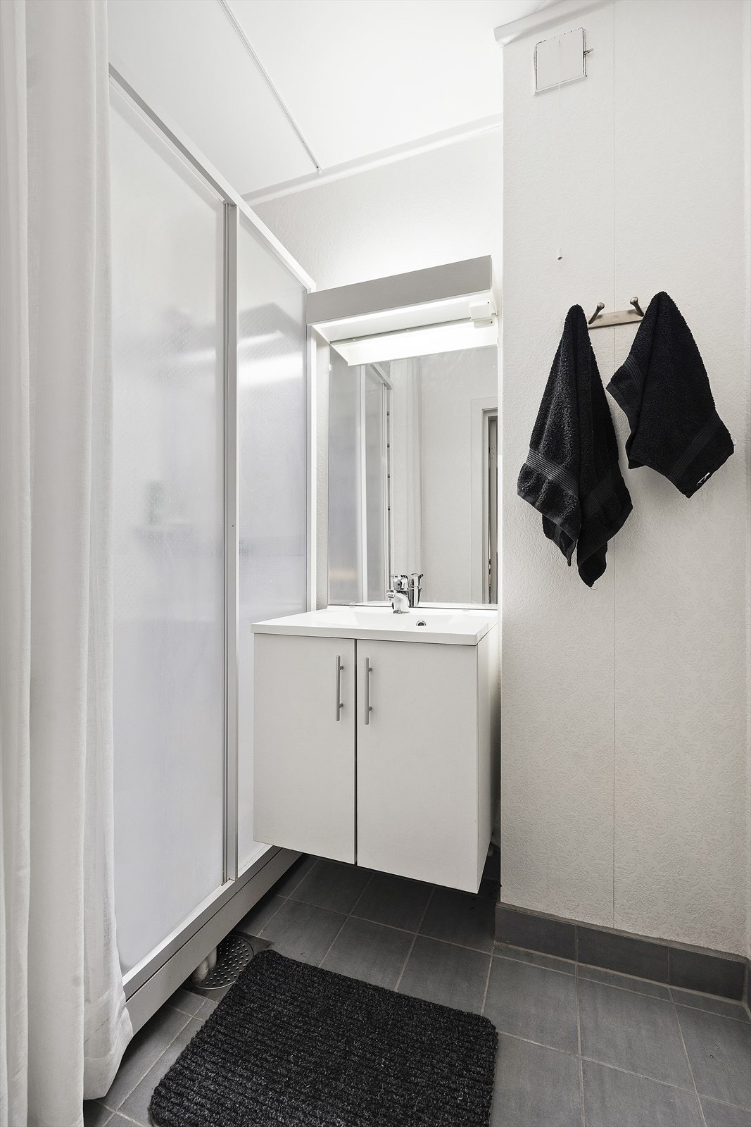 Bad med tilkomst fra soverommet. Badet har flislagt gulv m/varmekabler og har opplegg for vaskemaskin, dusjkabinett og innredning m/vask. Galleribilde