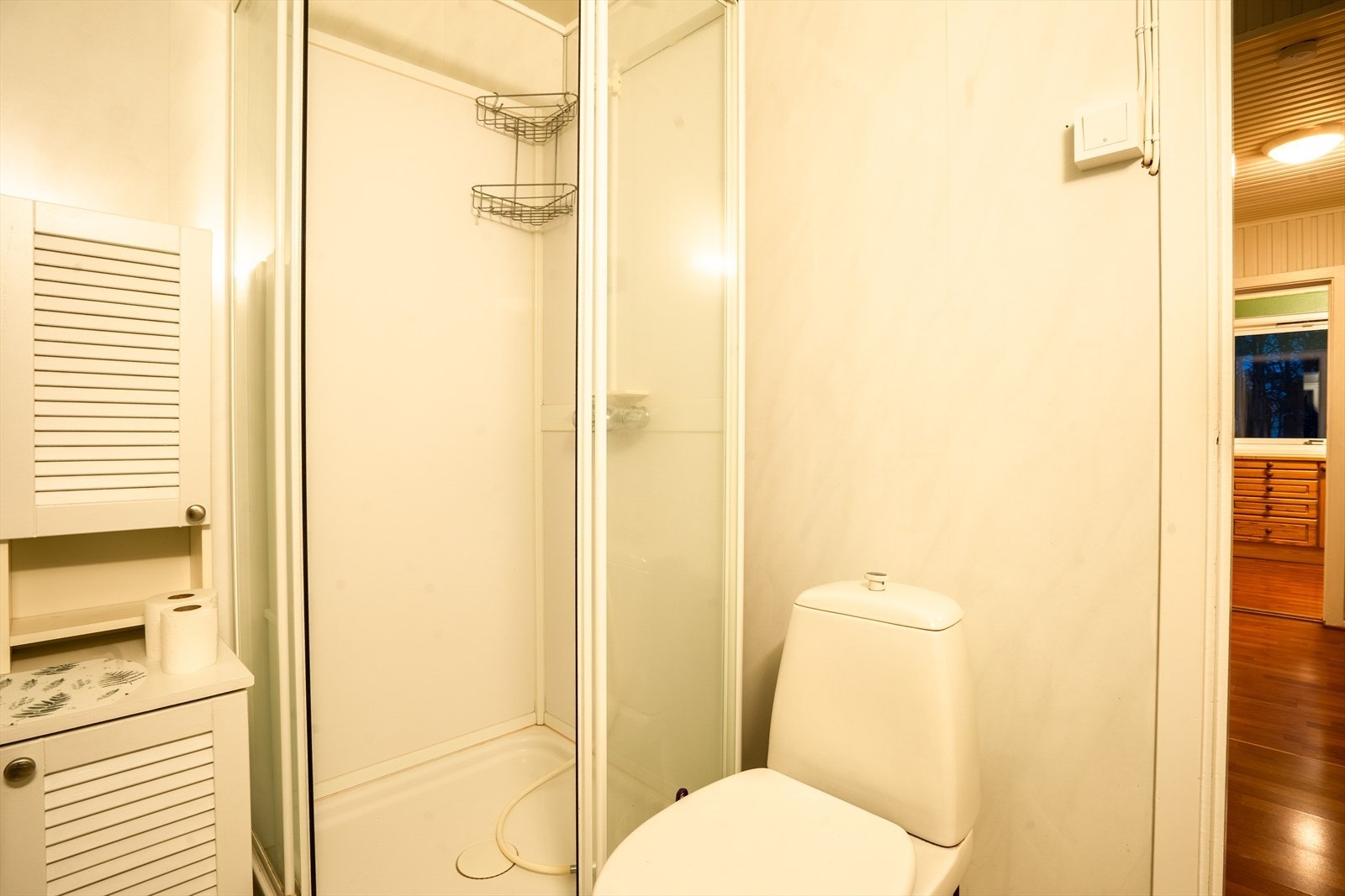 Lyst og funksjonelt bad med dusjkabinett og praktisk skapplass. Galleribilde