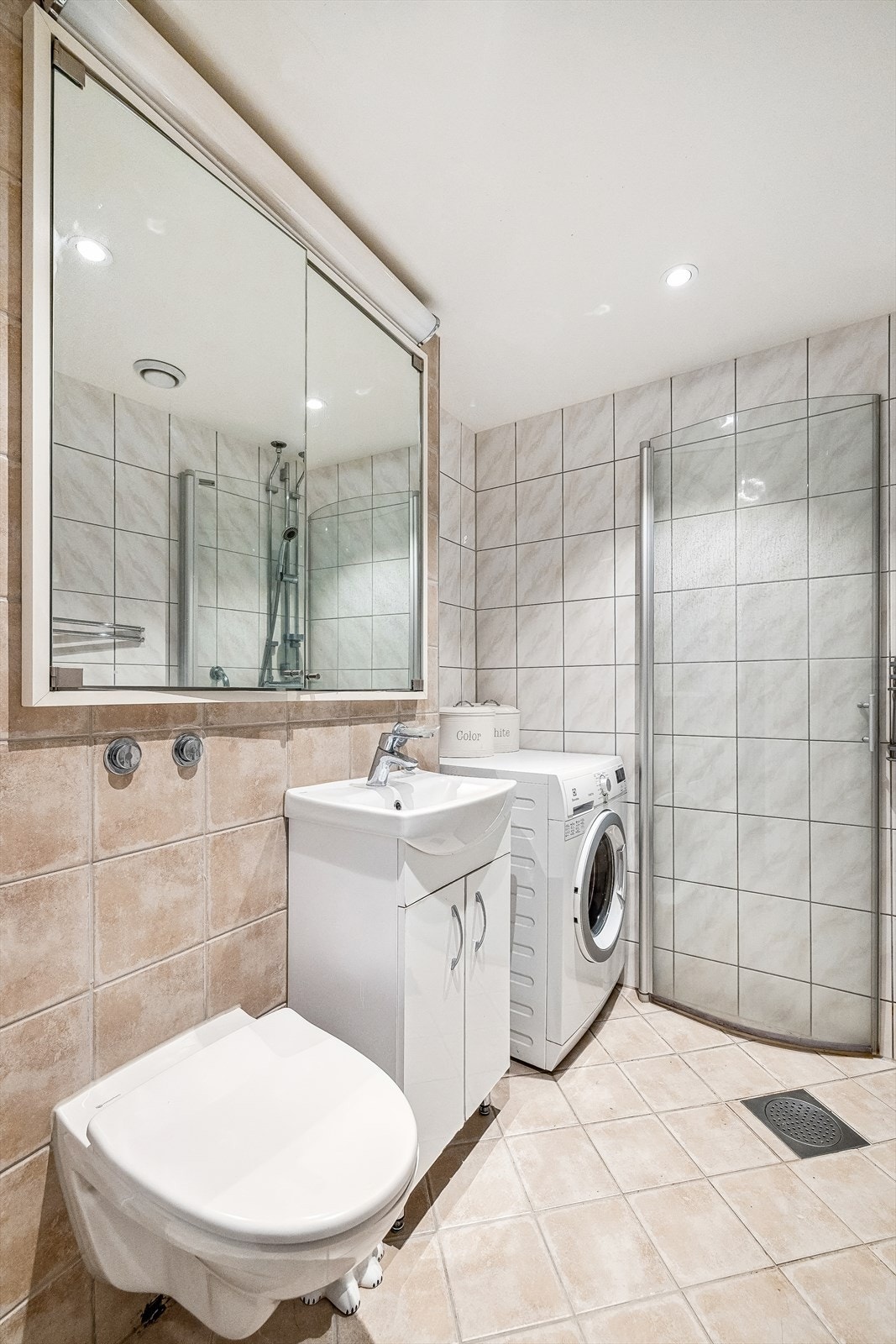 Baderommet er innredet med vegghengt toalett, servant over innredning, speil, dusjnisje med dører. Rommet har i tillegg opplegg for vaskemaskin. Galleribilde