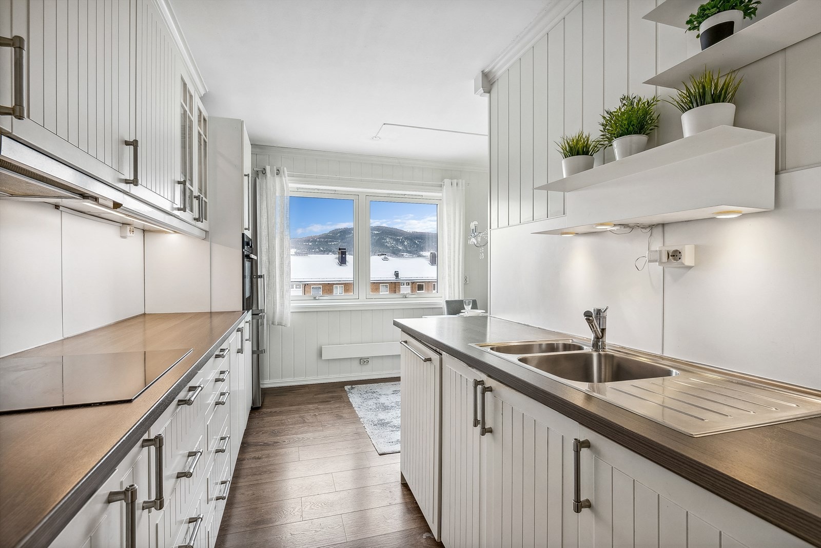 Innredningen har profilerte fronter, noen overskap med glassfronter og laminat benkeplate. Galleribilde