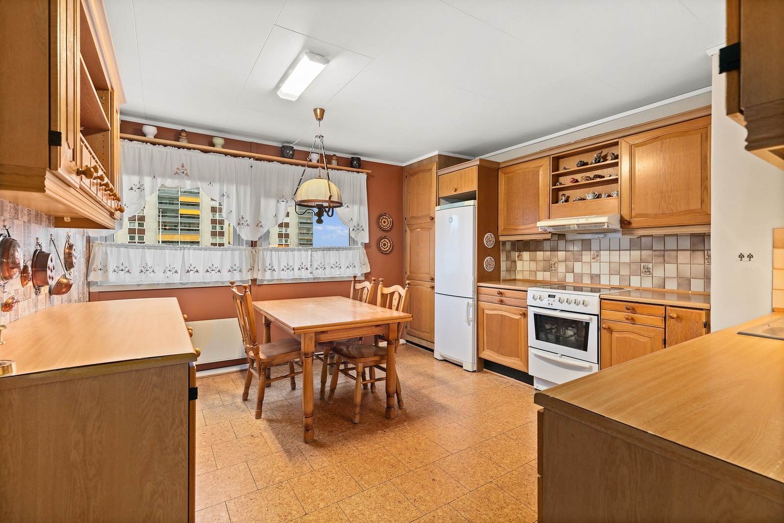 Kjøkkeninnredningen består av profilerte fronter og har benkeplate av laminat, og frittstående hvitevarer. Galleribilde