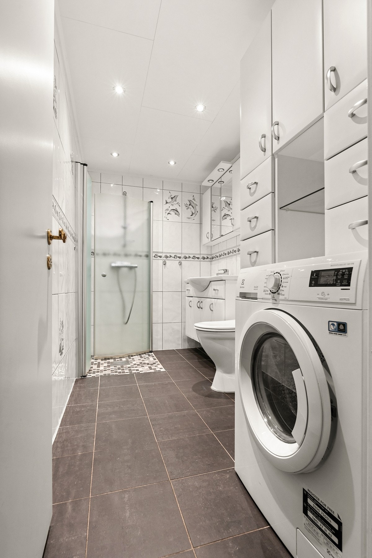 Badet har rikelig med oppbevaringsplass i skap, samt opplegg for vaskemaskin Galleribilde