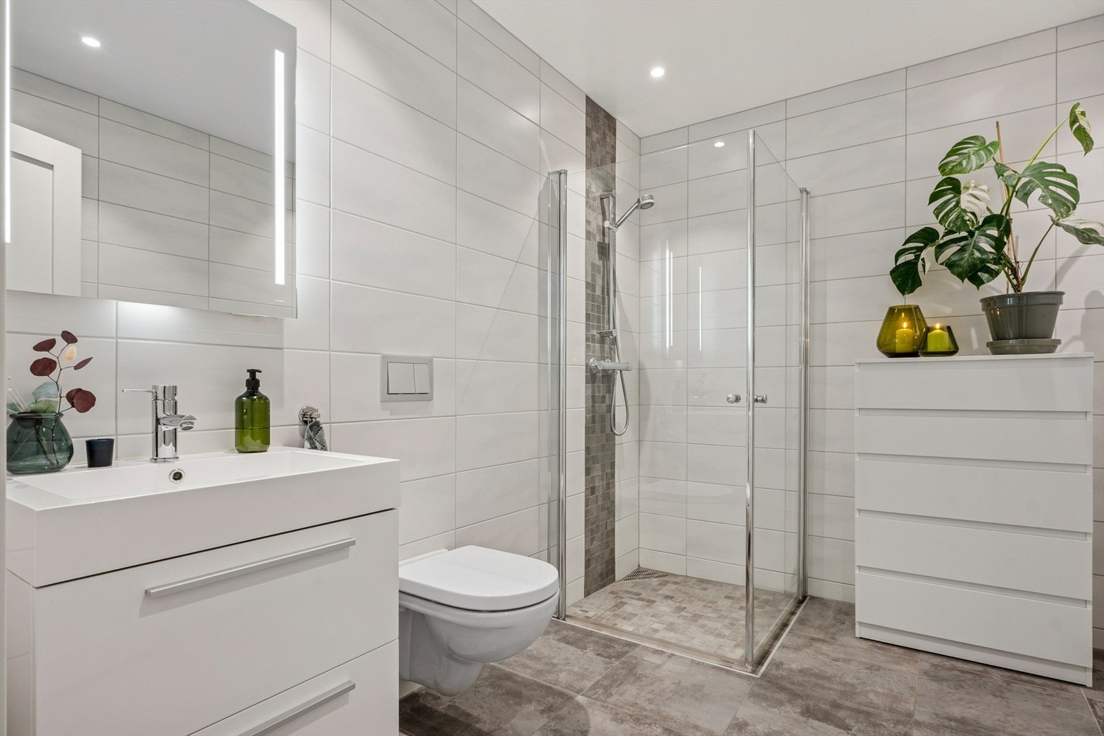 Boligen har to baderom og et vaskerom.
Baderommet som er beliggende i første etasje, er med fliselagte overflater på vegger og gulv. Galleribilde