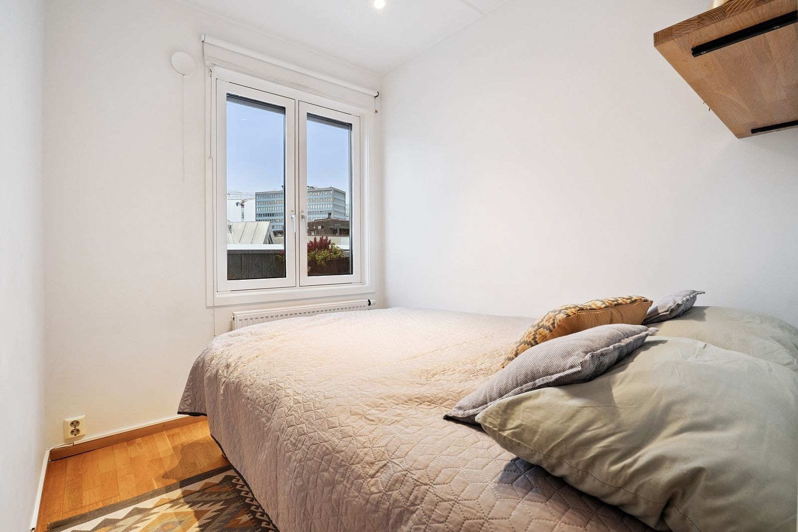 Lyst soverom med plass til seng og nattbord Galleribilde