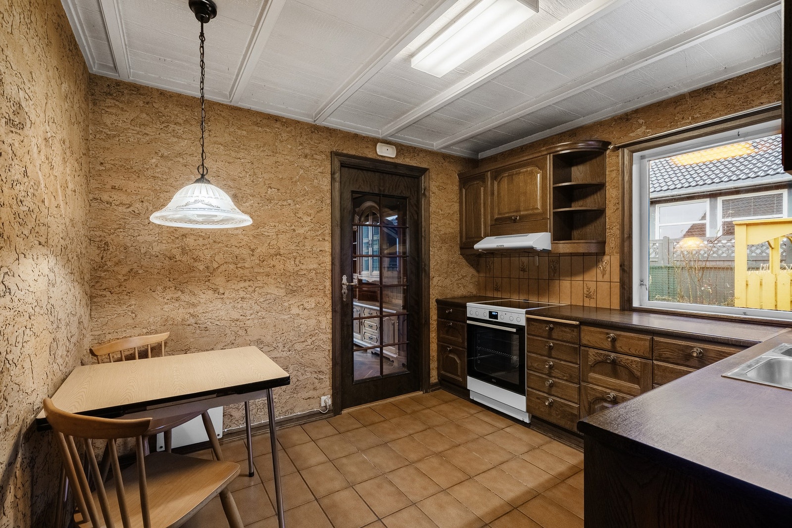 Eldre kjøkken med plass til et mindre frokostbord. Galleribilde