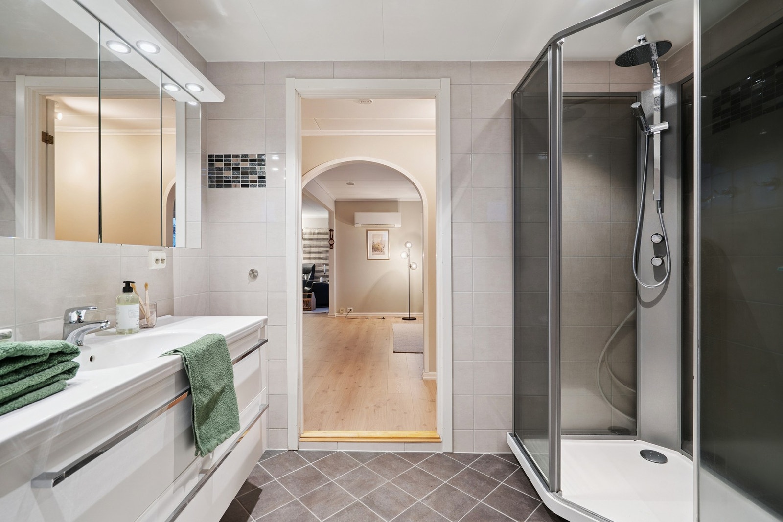 Badet er utstyrt med vegghengt innredning og dusjkabinett, samtidig som det er god plass til ekstra møblering Galleribilde