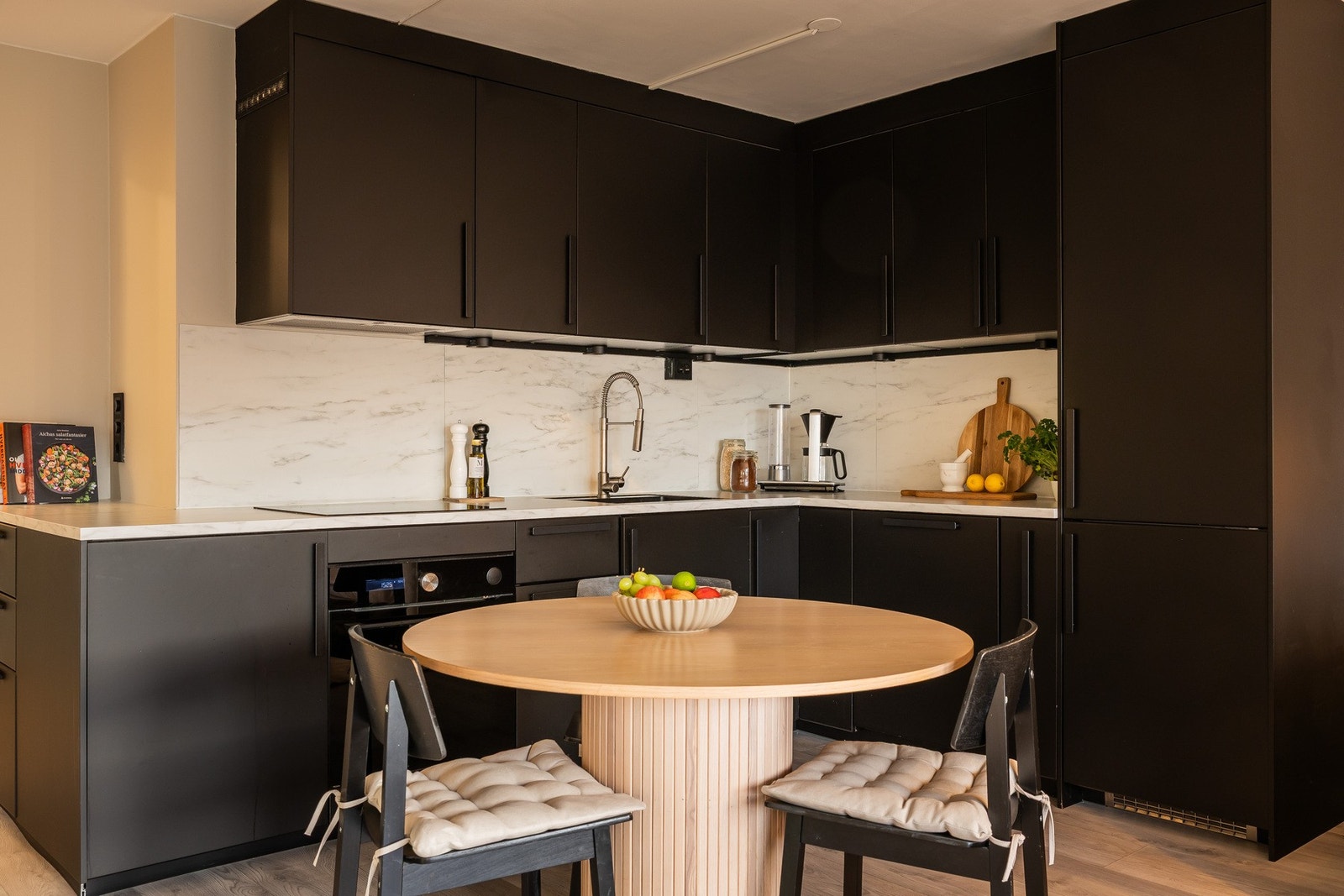 Pent kjøkken med glatte fronter og laminat benkeplate. Induksjon koketopp og innebygget stekeovn. Integrert kjøleskap/fryser og oppvaskmaskin. Galleribilde