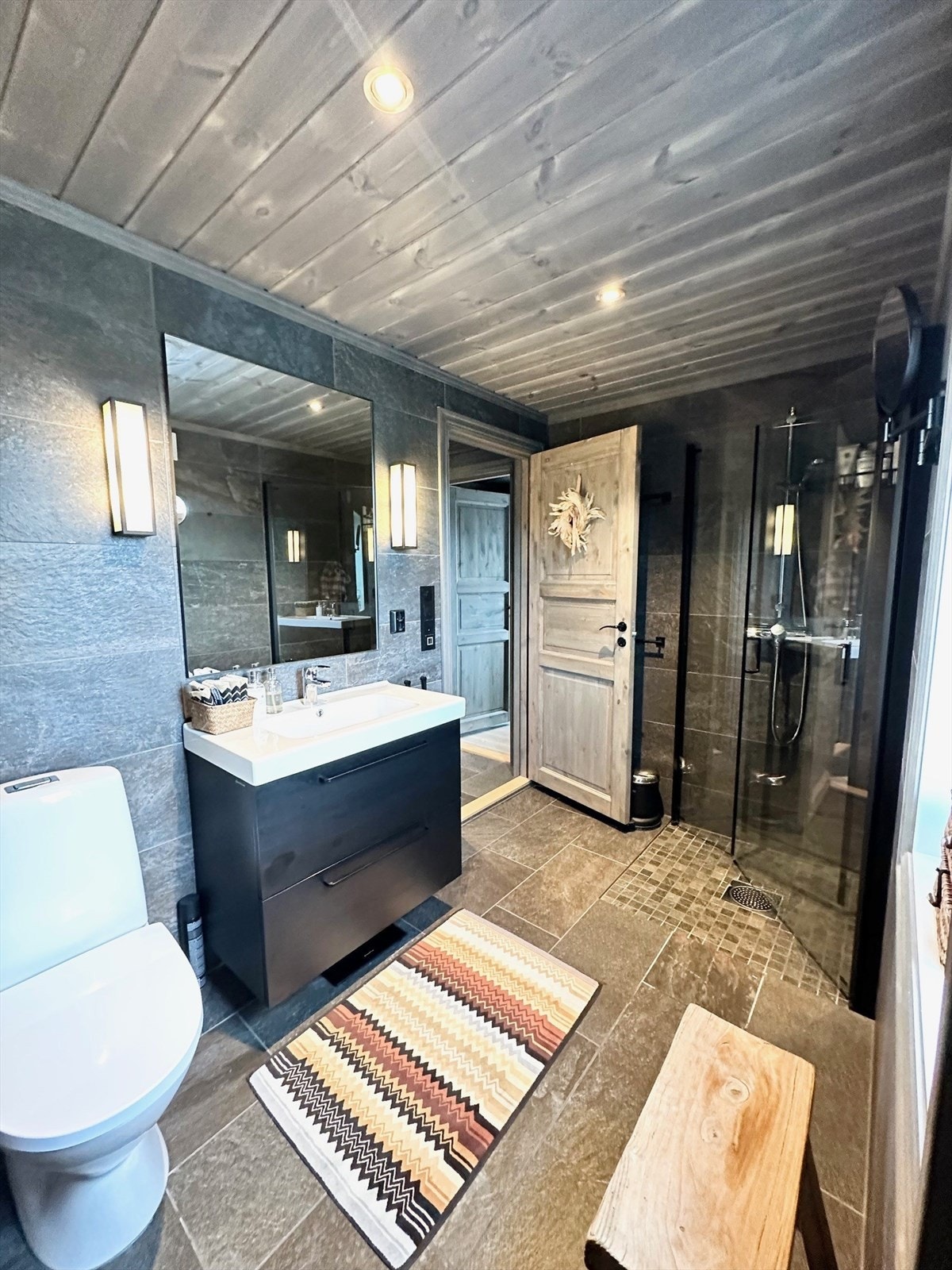 Ett av hyttens to bad, hvorav ett med tilknytning til badstue og ett med opplegg til vaskemaskin - den perfekte kombinasjon av moderne komfort og ekstra luksus. Galleribilde