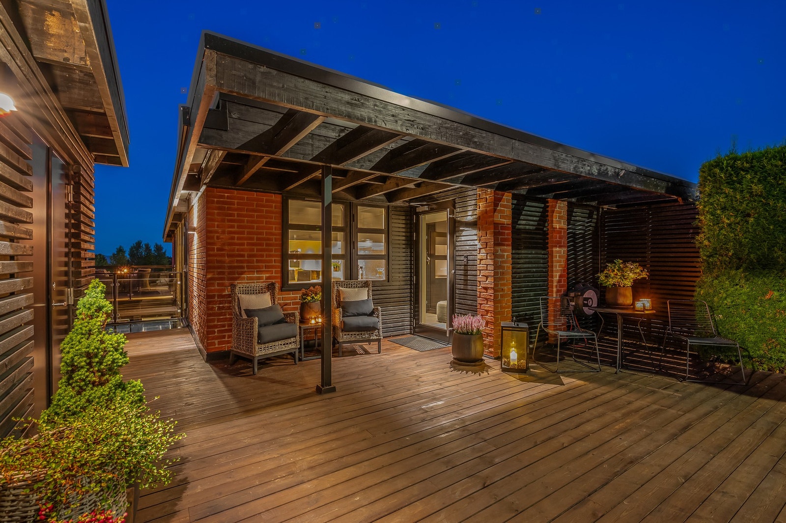 Skjermet inngangsparti med overbygg og terrasse på fremsiden av boligen. Galleribilde