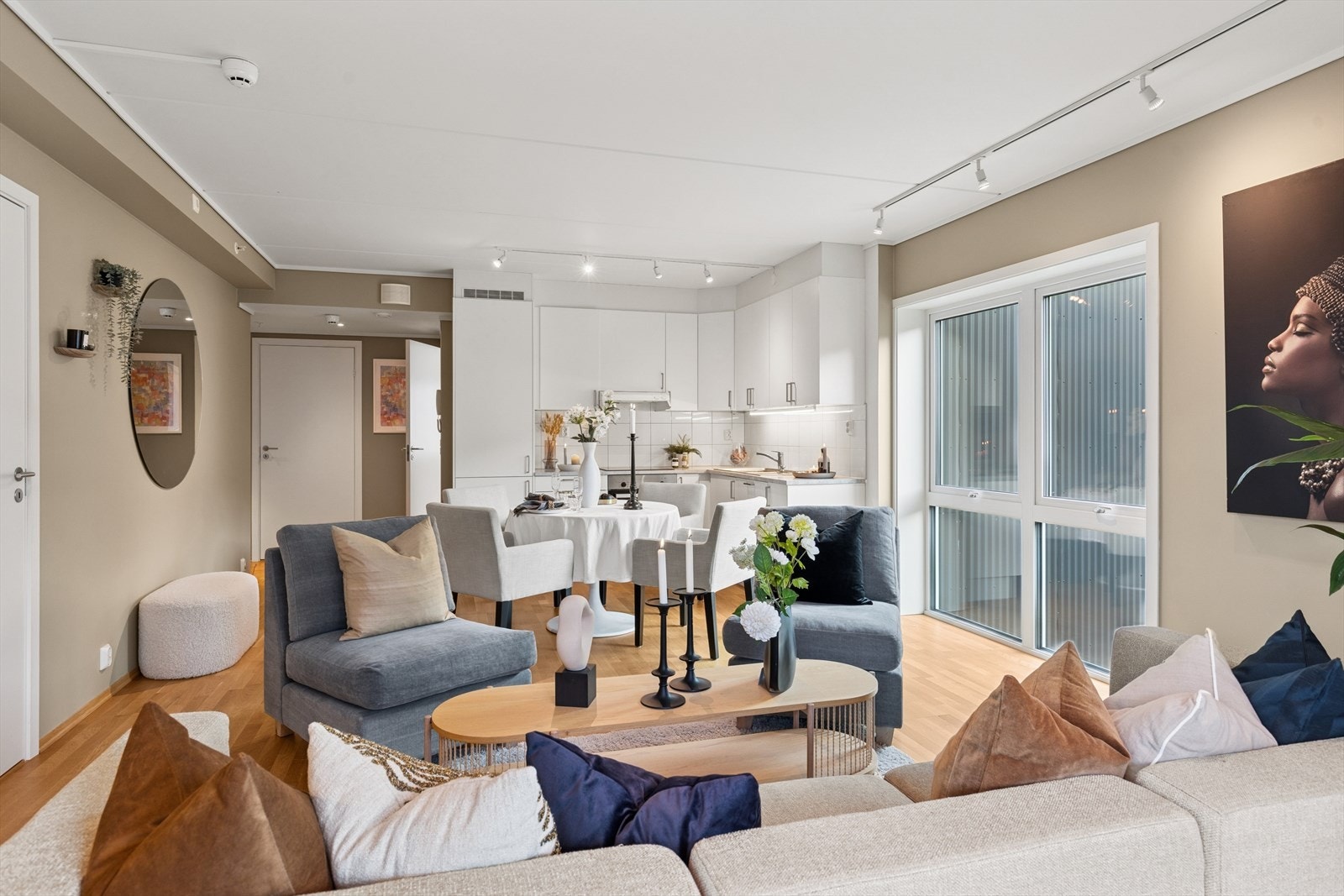 Leiligheten ligger inntrukket på hjørnet av bygget med flott lysinnslipp - her kan man kose seg i sofaen mens testen av gjestene skravler rundt spisestuebordet Galleribilde