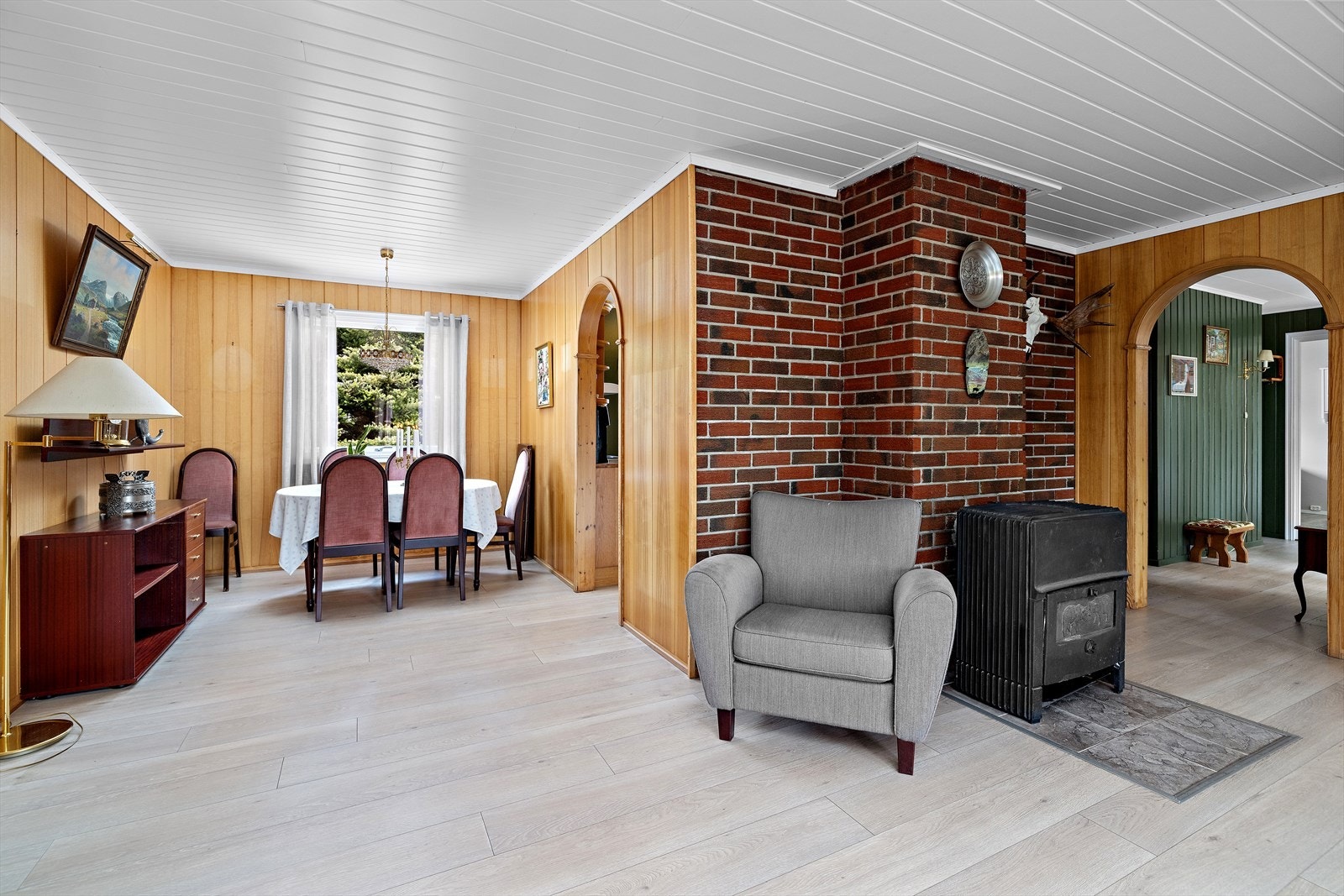 Lys og romslig stue med ildsted, varmepumpe og
plass til både sofa og spisebord. Galleribilde