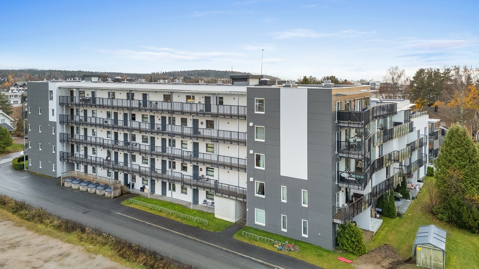 Fasade. Asfaltert adkomst til blokken, samt gjesteparkering og sykkelparkering. Galleribilde