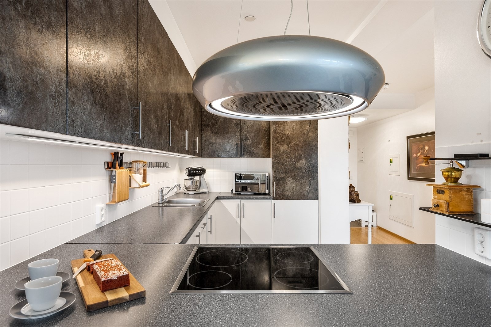 Det er en nyere og moderne kjøkkenventilator med fjernkontroll over platetoppen. Galleribilde