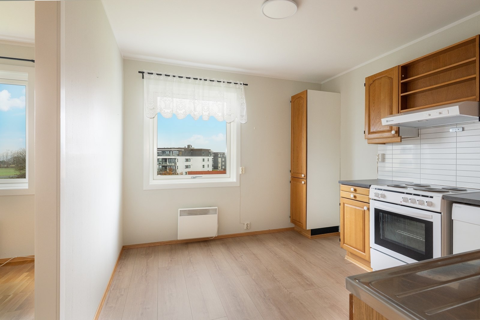 Lyst og koselig kjøkken med plass for kjøkkenbord ved vindu. Galleribilde