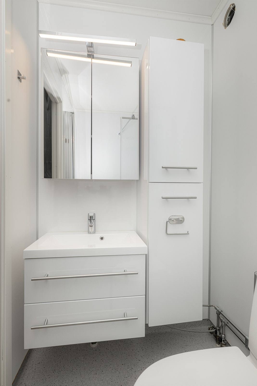 Badet har vinylbelegg på gulv og baderomsplater på vegger. Galleribilde