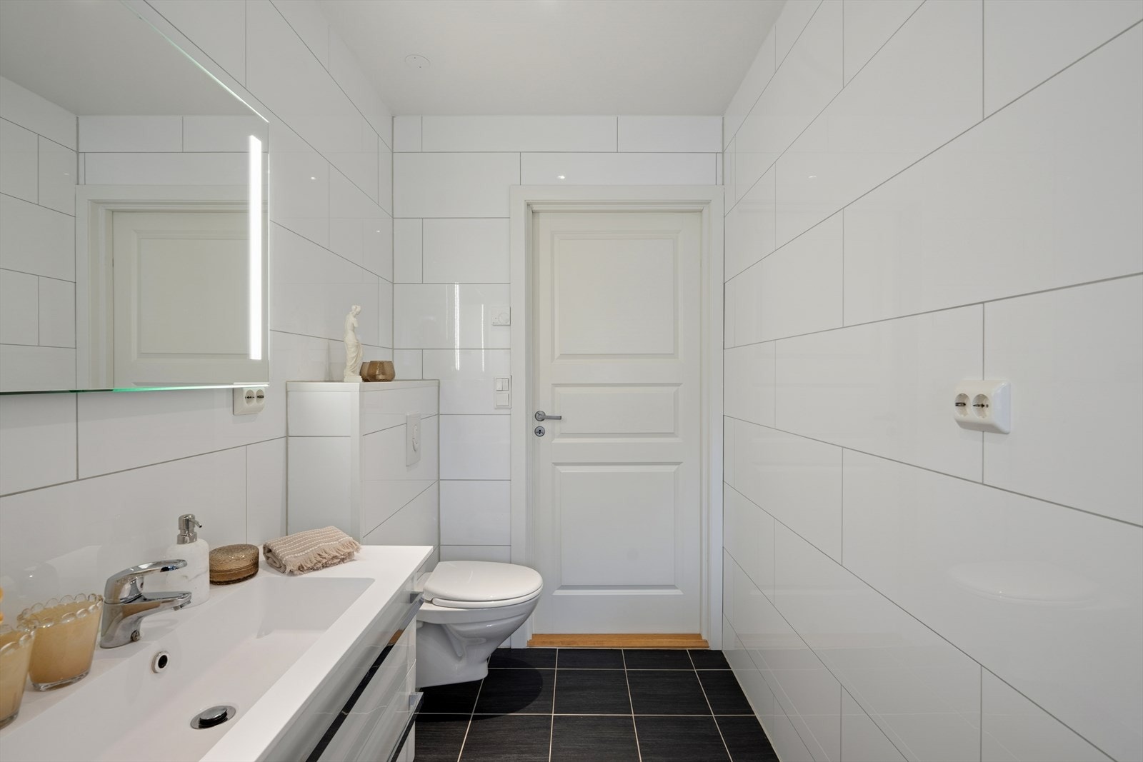 Rommet er innredet med speil med lys, servant med seksjon, dusjkabinett, vegghengt toalett, utslagsvask og har opplegg for vaskemaskin. Galleribilde