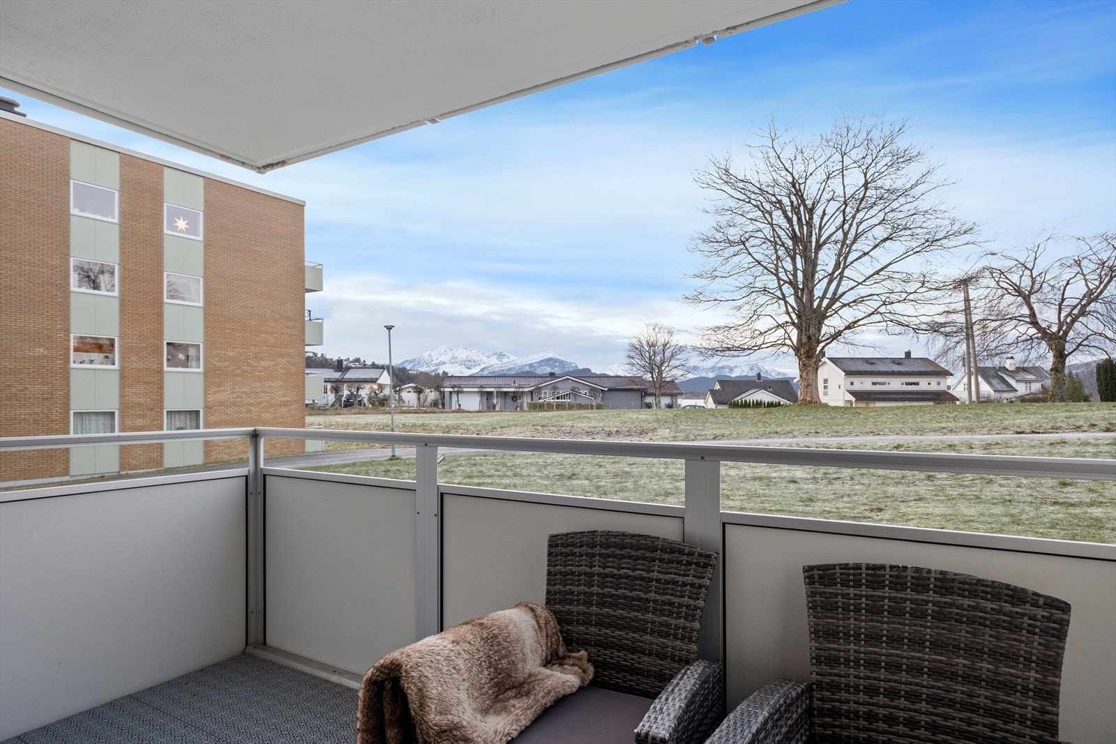 Balkongen har utsikt mot nærliggende fjell og boligområde. Galleribilde