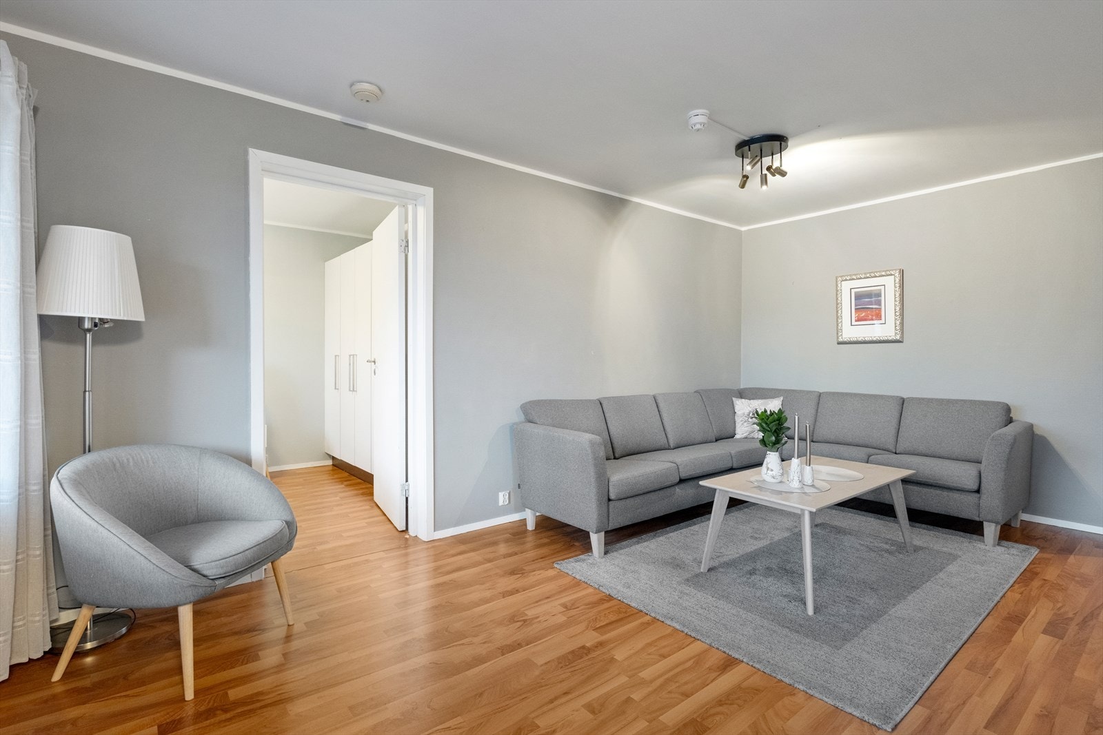 Lysmalte vegger og parkettgulv gir en nøytral og tidløs base i stuen. Galleribilde