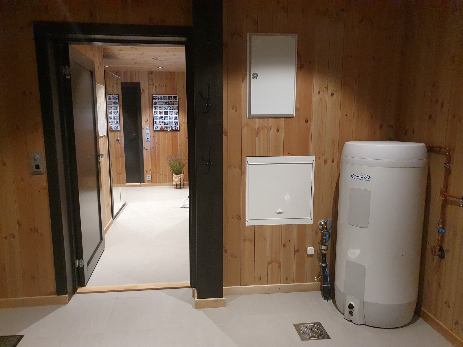 Sikringsskap og varmtvannstank. Stoppekran og kran på vegg inne, og ut til frostfri kran på utevegg. Galleribilde