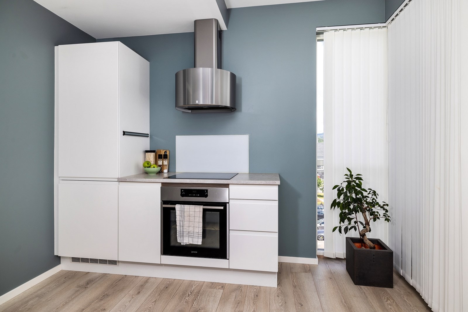 Kjøkkenet er utstyrt med komfyr, platetopp, kombiskap og servant innredning Galleribilde