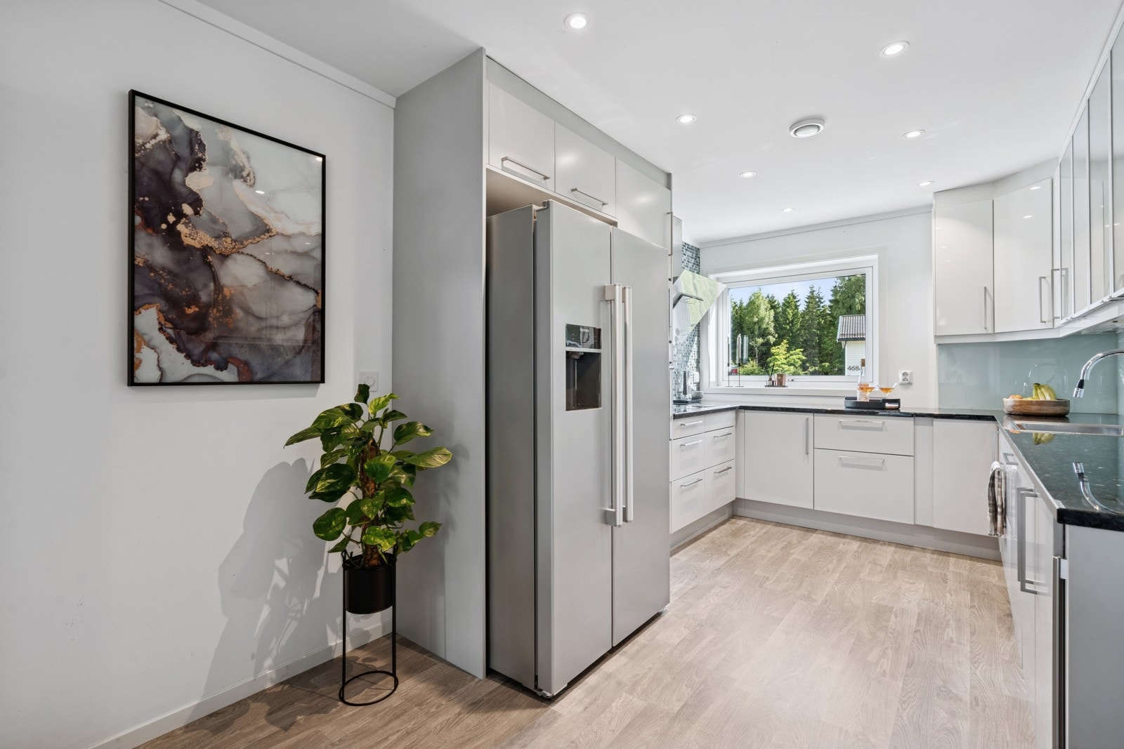 Kjøkkenet leveres med integrerte hvitevarer fra Siemens, Et side-by-side-kjøleskap gir rikelig med oppbevaringsplass og god oversikt over matvarene, samt en vinkjøler for ekstra komfort. Det er downlights med dimmere på kjøkkenet. Galleribilde