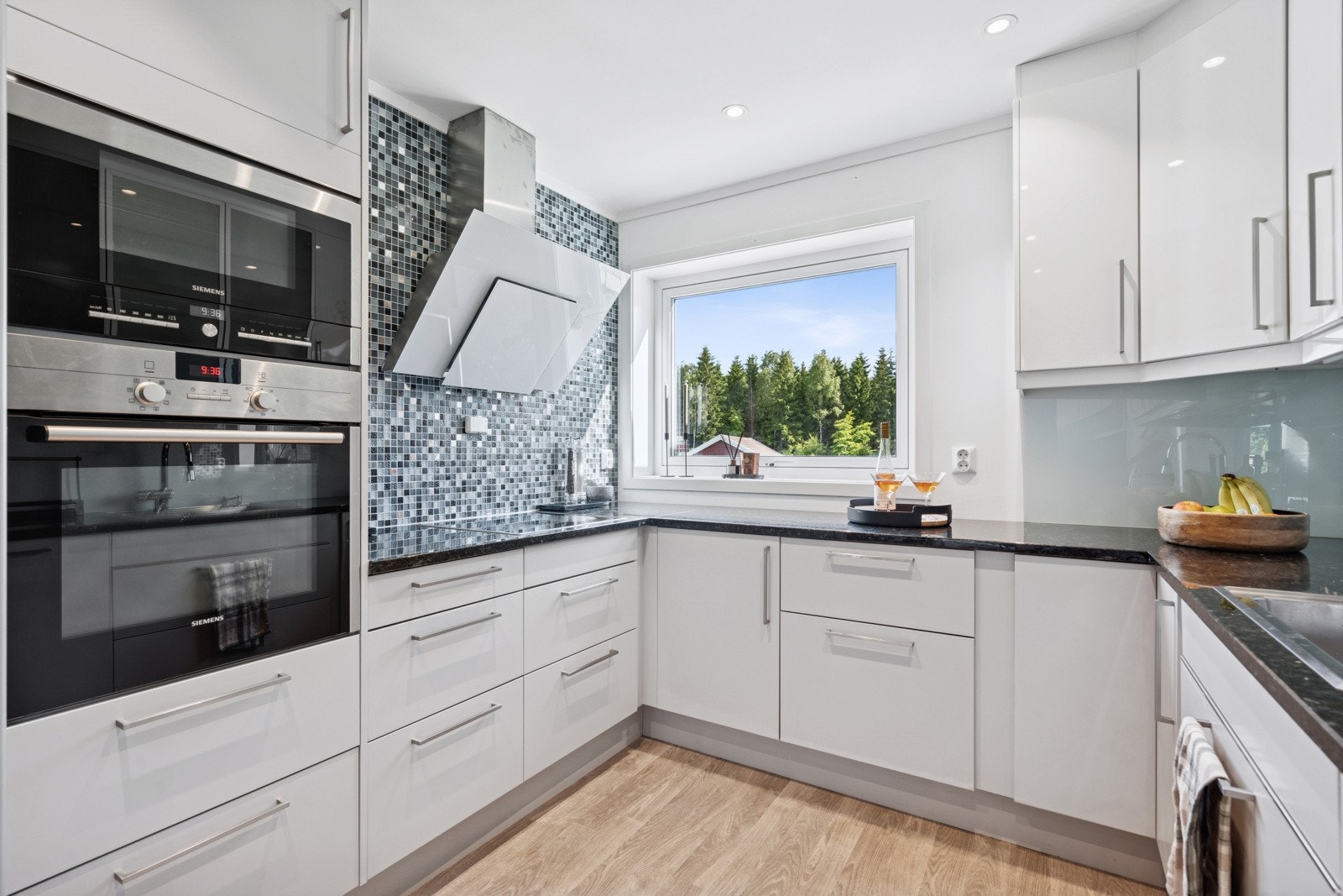 Kjøkkenet fra Sigdal er delikat og innholdsrikt, med rikelig skap- og skuffeplass, samt en 7,7 meter lang benkeplate i Lundhs Emerald stein som tåler hard bruk uten tegn til slitasje.Mosaikkglassflisene skaper et praktisk og stilrent uttrykk. Galleribilde