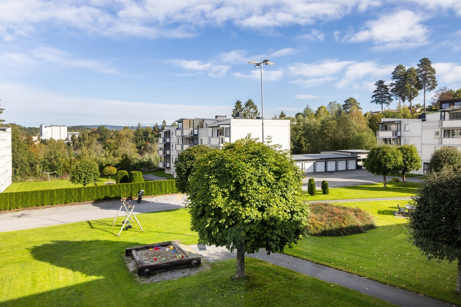 Store grøntarealer med sittegrupper, sandkasser og lekeapparater Galleribilde