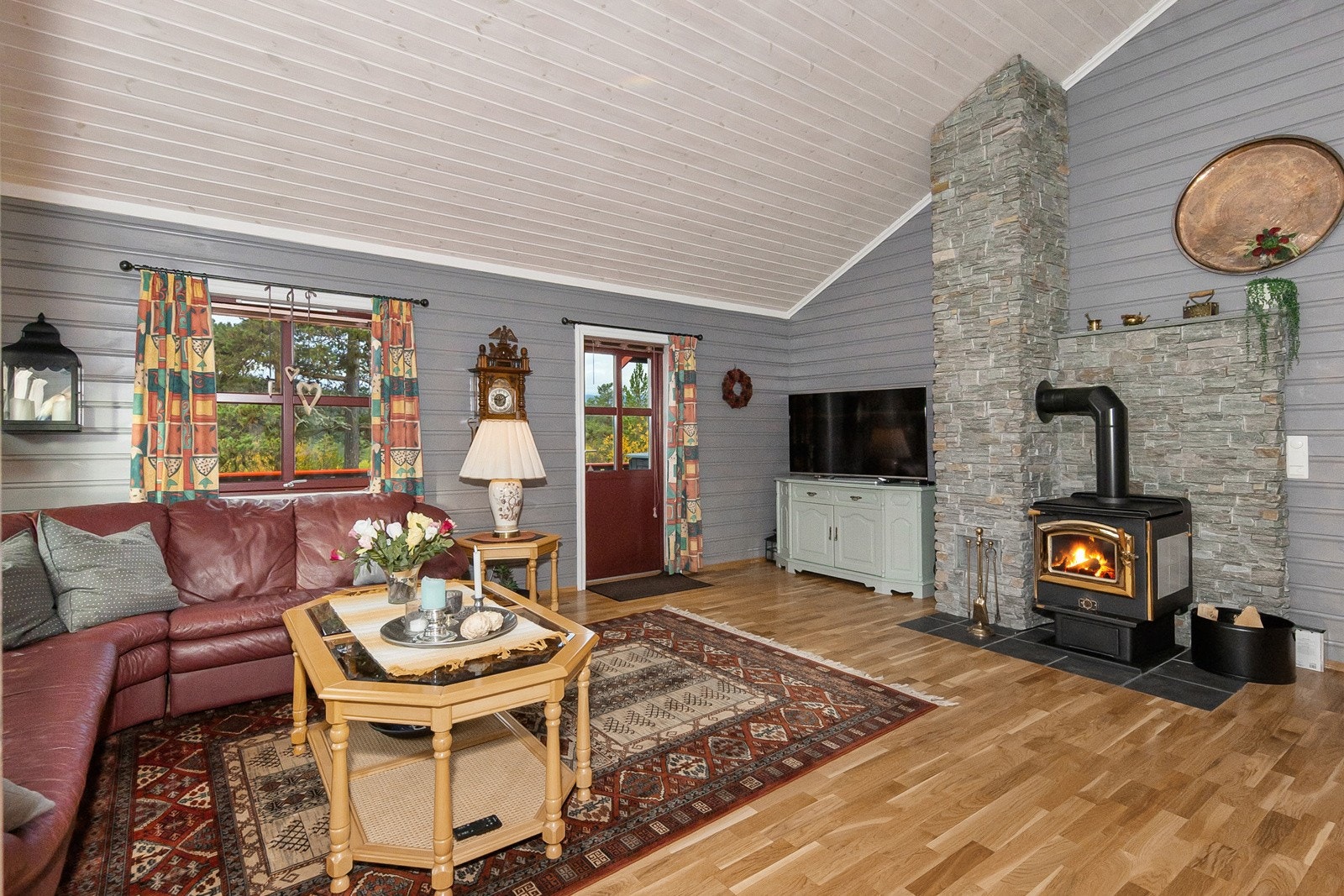 Vedovn med nydelig plassering midt i stuen, og den sees både fra sofa og spisestue. God varme på kalde dager eller en pinne eller to for kosens skyld Galleribilde