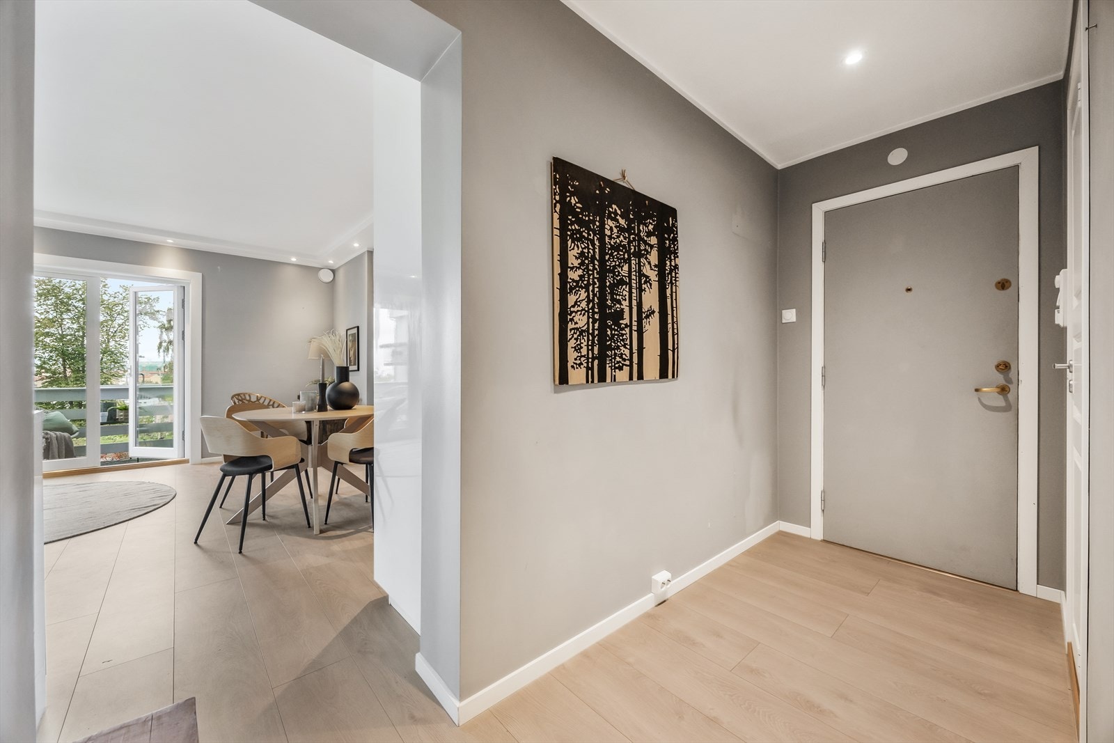 Velkommen inn i en lys entré som leder videre inn i leilighetens oppholdsrom Galleribilde
