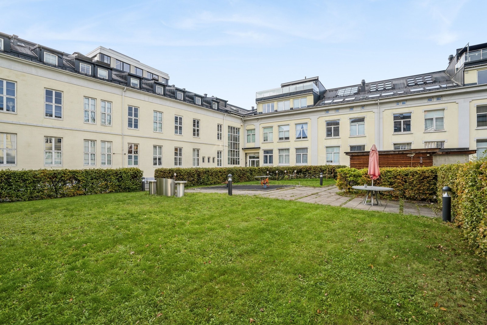 Frodig felles bakgård med sittegrupper, grill og sykkelparkering Galleribilde