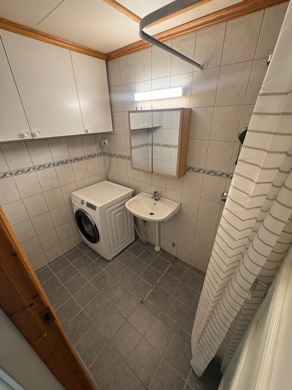 Flislagt bad med medfølgende vaskemaskin. Galleribilde